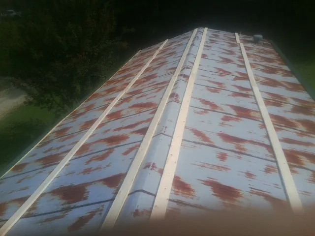 Rusted metal roof panels with new wood purlins before replacement — Storm Damage Roof Repair in Orange City by Roofing Brothers